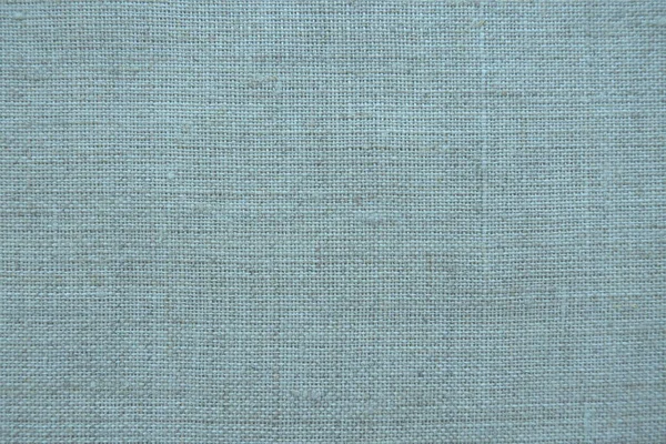Fabric texture background. Blue fabric with weave. Natural slightly wrinkled look of the material. Uniform copy space background. Cotton, canvas or woolen thin fabric laid evenly on the surface