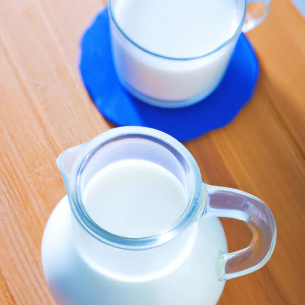 ガラスのカップとカフェでミルク トップビュー 茶色の木製のテーブルの上に青ナプキン 乳製品の天然製品を宣伝するためのテンプレート キッチン用品 ミルクとジャグ — ストック写真