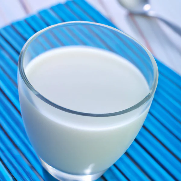 ガラスのカップの上からミルク ラベンダーの木のテーブルの上に青ナプキン 乳製品の天然製品を宣伝するためのテンプレート キッチン用品 — ストック写真