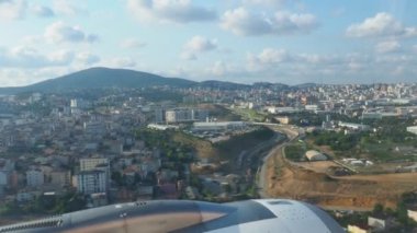 Türkiye 'nin başkenti İstanbul üzerinde bir yolcu uçağı uçuyor. Evler, İstanbul sokakları. Uçak motoru, manevralar. Uçuş, seyahat ve turizm. Pencere deliğinden bak. Türbülansa giren uçak..