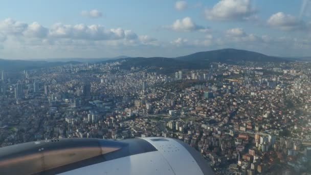 一架客机飞越土耳其首都伊斯坦布尔上空 伊斯坦布尔的房子 飞机引擎 旅行和旅游 从舷窗往外看天空 — 图库视频影像