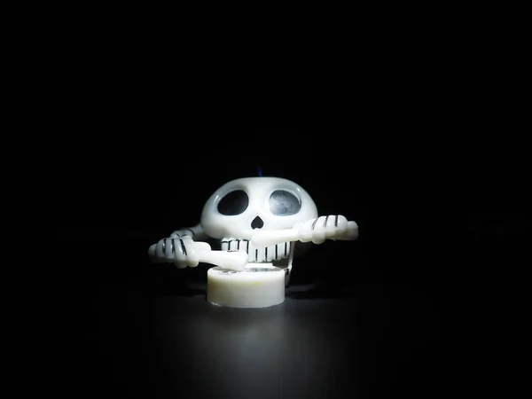 骷髅用鸡腿和鼓 可怕的钟表玩具 骷髅是由骷髅 手和手指组成的 黑色背景 万圣节和恐怖的主题 黑色眼窝的白色颅骨 — 图库照片