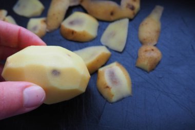 Patates yumrusunun mantar, viral ya da bakteriyel enfeksiyonu. Patatesin içindeki siyah noktalar. Noktalı çiğ patates ve bir kadının elinde bir delik. Gıda güvenliği. Doğal tarım ürünleri tehlikesi