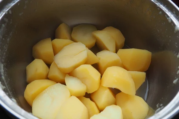 金属鍋でゆで卵ジャガイモをゆで卵 トップビュー 皮をむいたジャガイモのみじん切り部分をゆでた 料理を作る 食品の熱処理 調理のための食品成分 黄色いジャガイモ — ストック写真