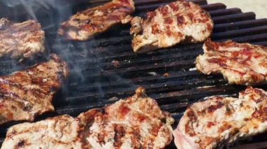 Izgaradaki eti çatalla hareket ettir. Yemek pişiren el. Izgarada ızgara ızgarada ızgara domuz etli biftek, etkin duman. Izgara sulu biftek piknik kutlaması için hazır..