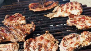 Kanlı biftek. Izgarada ızgara ızgarada ızgara, alevler ve duman içinde ızgara etli domuz eti. Izgara sulu biftek piknik kutlaması için hazır. Barbekü ızgarası