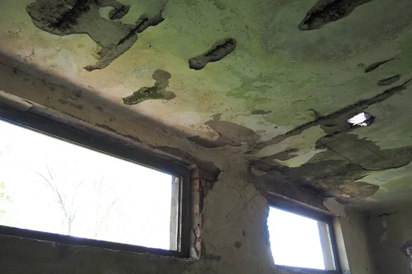 放棄された建物のインテリア 壁に空の壊れた窓 ほこりやクモの巣を持つみすぼらしい荒涼とした部屋 漆喰が壁に落ちた 穴が開いています 建物の倒壊 — ストック写真