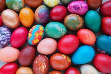Paskalya renkli yumurtalar yakında. Birçok renkli tatil yumurtaları birbirine yakın istiflenmiştir. Haşlanmış tavuk yumurtası, çiçek ve fantezi desenli. Parlak Paskalya arkaplanı
