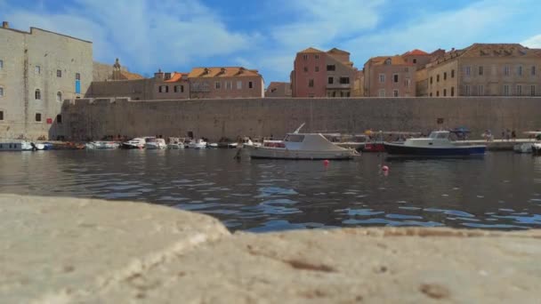 ドゥブロヴニク クロアチア 2022旧市街 赤い屋根 港と古代の建物 市の港 喜びのボートの係留 人々は桟橋に沿って歩いている ポルポレラの城壁 ドゥブロヴニク旧港 — ストック動画