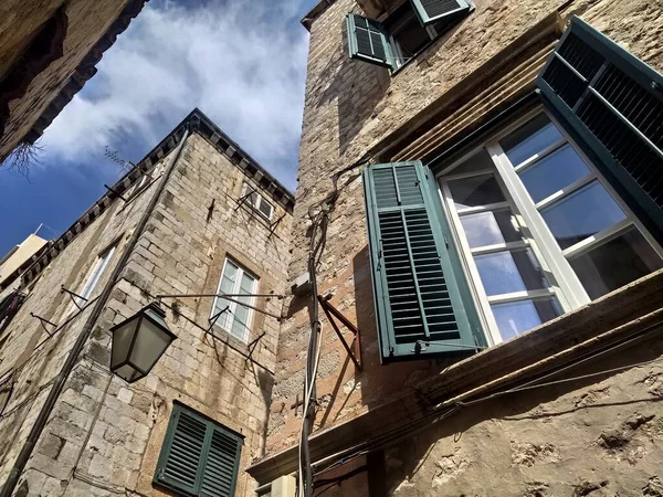 2022年8月14日クロアチアのドゥブロヴニク旧市街の通り 家のファサードは石でできている アドリア海の夏の観光 ヴィンテージストリートランプ 空はシャッターが付いている窓に反映される — ストック写真