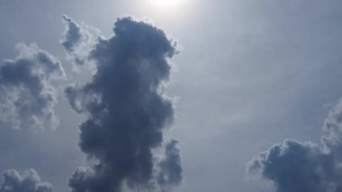 Zaman, bulutlu ve güneşli güzel mavi gökyüzünü hızlandırıyor. Bulutların hızlı hareketi. Açık beyaz bulutlar hızla akıyor. Ses ötesi ışık. Güneş ışınları. Hafif kümülüs yırtık bulutlar çabucak başka bir şekle dönüşür.