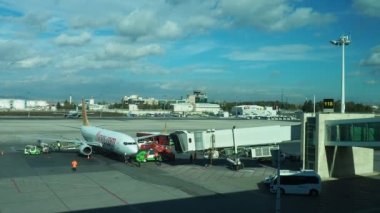 Ankara, Turkey, Esenboga Havalimani Airport, 01.19.2023. view from the window of the passenger terminal on the runway area. Airplane bridge. Passengers with suitcases disembark from the plane. Clouds