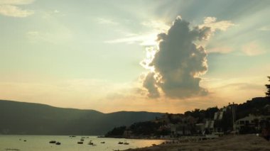 Kotor Körfezi 'nde güzel bir yaz günbatımı, Karadağ' ın Herceg Novi kentinin manzarası. Cumulus güneşi kaplayan dikey bir buluttur. Dağlar ve deniz suyu. Adriyatik Denizi, Akdeniz