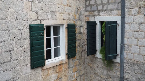 古い家の緑の閉じたシャッター付きの古い窓 ヴィンテージ感 ヘレグ ノヴィモンテネグロ古い石造りの家 アドリア海地域の建築 壁に窓やシャッターを固定する — ストック写真