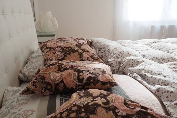 床上用品上的粉红色装饰枕头 双人床 有枕头和厚厚的羽绒被 卧室设计 柔软的白色床头板 内饰家具和床上用品 — 图库照片