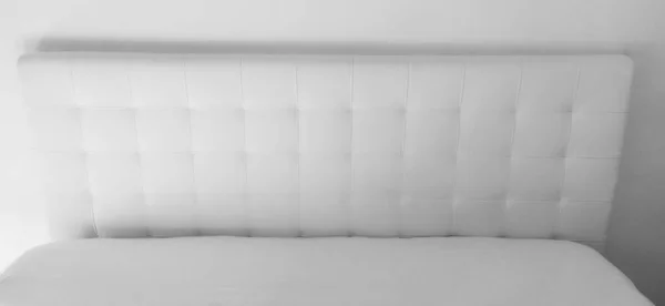 软硬的床头板真皮或人造皮革及棉被织物制成的家具用的不干胶 软硬的床头板靠着轻便的墙壁 黑白单色照片 — 图库照片