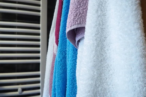 毛巾挂在加热的毛巾栏杆 墙壁散热器或散热器旁边 红色毛巾 在浴室里整理家用物品 家政服务 — 图库照片