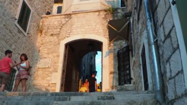 Herceg Novi, Karadağ 08.10.2022 Sahat Kula saat kulesi, iki kare arasındaki bir geçit - Nikola Curkoviç ve Belavista. Bu popüler bir turistik ilgi odağı. Turistler merdivenlerden inip çıkıyorlar.
