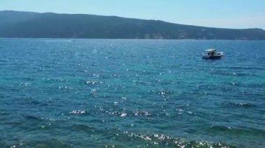 Herceg Novi, Karadağ 08.13.2022 Deniz Tatili. Adriyatik Denizi 'nde tekneler yüzer. Akdeniz seyahat işi. Yelkenliler ve dağlar. Su dalgalanmaları. Güneşli bir hava. Balık tutmak rahatlatır. Turkuaz dalgalar