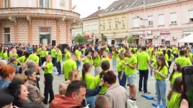 Sırbistan 'ın Sremska Mitrovica kenti, 19 Mayıs 2023 Mezunlar Balosu ve merkez meydandaki teknik okullar. Gençlik kolektif dans gösterisi yapıyor. Kızlar ve erkekler yeşil tişört giyer. Mezuniyet günü..