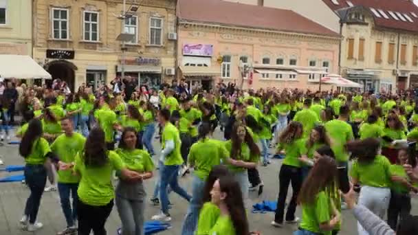 Sremska Mitrovica Service May 2023中央広場にある学校や専門学校の卒業生のボール 若者は集団ダンスをする 女の子と男の子は緑のTシャツを着ています 卒業式の日 — ストック動画