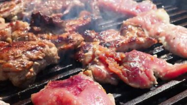 Izgarada ızgara ızgarada ızgara, alevler ve duman içinde ızgara etli domuz eti. Izgara sulu biftek piknik kutlaması için hazır. Barbekü ızgarası