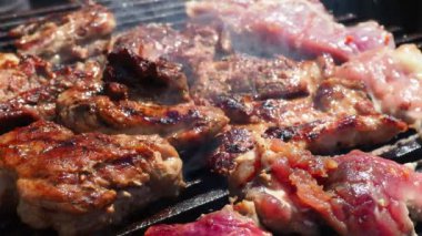 Izgarada ızgara ızgarada ızgara, alevler ve duman içinde ızgara etli domuz eti. Izgara sulu biftek piknik kutlaması için hazır. Barbekü ızgarası