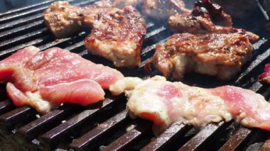 Izgarada ızgara ızgarada ızgara, alevler ve duman içinde ızgara etli domuz eti. Izgara sulu biftek piknik kutlaması için hazır. Barbekü ızgarası