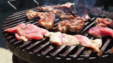 Izgarada ızgara ızgarada ızgara, alevler ve duman içinde ızgara etli domuz eti. Izgara sulu biftek piknik kutlaması için hazır. Barbekü ızgarası