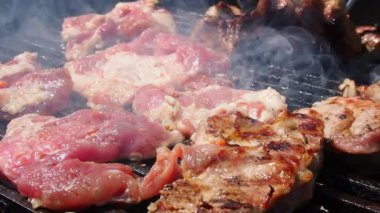 Izgarada ızgara ızgarada ızgara, alevler ve duman içinde ızgara etli domuz eti. Izgara sulu biftek piknik kutlaması için hazır. Barbekü ızgarası