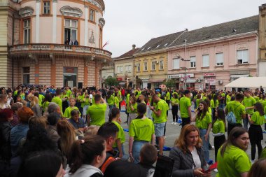 Sırbistan 'ın Sremska Mitrovica kenti, 19 Mayıs 2023 Mezunlar Balosu ve merkez meydandaki teknik okullar. Gençlik kolektif dans gösterisi yapıyor. Kızlar ve erkekler yeşil tişört giyer. Mezuniyet günü..