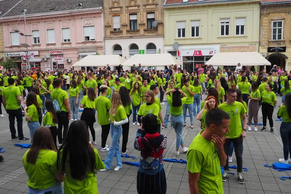 stock image Sremska Mitrovica, Serbia, May 19 2023 Ball of graduates of schools and technical schools on the central square. Youth performs a collective dance. Girls and boys wear green t-shirts. Prom degree day.