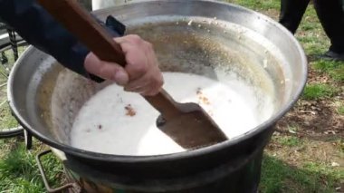 Kömürün üzerinde büyük bir fıçıda yağ karıştırmak. Domuz derisi, domuz derisi için kullanılan bir mutfak terimidir. Pişirebilir, yağda kızartabilir, pişirebilir, domuz çıtırtısı veya çizik üretmek için kızartabilir. Sırbistan Srem.
