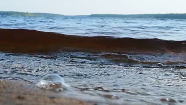 洛希扎维 Lososinskoye Lososinnoye Lohijarvi 是卡累利阿共和国普里奥涅茨基地区的一个水库湖泊 傍晚时分 海浪在沙滩上冲撞 带来了气泡和泡沫 慢动作 — 图库视频影像