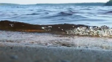 Lososinskoye, Lohijarvi, Karelia Cumhuriyeti 'nin Prionezhsky bölgesinde yer alan bir göldür. Akşamları, köpükler, damlalar ve köpüklerle kumlu kıyıya vuran dalgalar. Yavaş çekim.