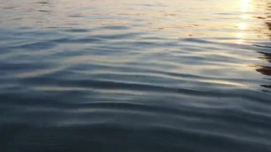 Mavi gök mavisi su dokusu yukarıdan aşağıya doğru görünüyor. Su yüzeyi. Gecenin mavi saatinde yumuşak dalgalar dalgalanır. Hidrodinamik dengesizlik durumunda bir hacimde kendiliğinden oluşan dalgalar. Gün batımı.