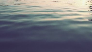 Mavi gök mavisi su dokusu yukarıdan aşağıya doğru görünüyor. Su yüzeyi. Gecenin mavi saatinde yumuşak dalgalar dalgalanır. Hidrodinamik dengesizlik durumunda bir hacimde kendiliğinden oluşan dalgalar. Gün batımı.