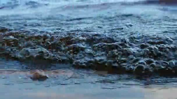 傍晚时分 海浪在沙滩上冲撞 伴随着气泡 水滴和泡沫 惊心动魄的湖面 海洋在风的影响下 日落娱乐用水运动 — 图库视频影像