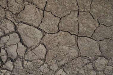 Zemin, kuraklık ve ölüm kavramına sahip arka plan veya grafik tasarımı için üst görünümde çatlaklar var. Kuraklık, uzun süreli su kıtlığı olgusudur. Oturaklı yüksek anti-klon.