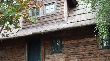Sırp-Bosna ahşap mimarisi. Yaz köyü Balkan sahnesi. Huş dalları rüzgarda uçuşuyor. Çatıda ahşap kiremitlerden yapılmış eski bir ev. Etnik halk turizmi. Stanisici, Bielina