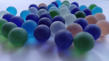 Oyun kumandaları ya da beyaz arka plana saçılmış renkli cam toplar. arka ışıklandırma.