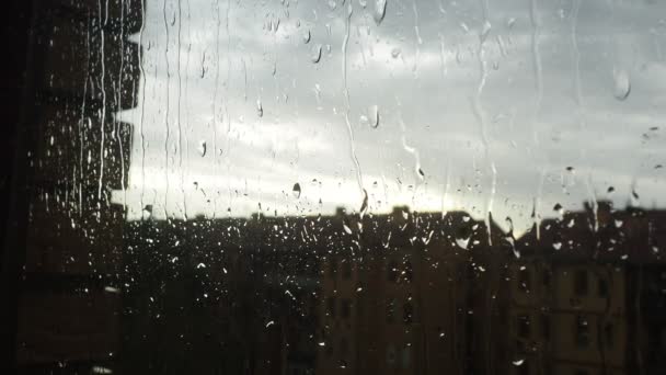 玻璃与雨滴滴特写电影 远处浓重的灰云让位给晴朗的天空 水从窗户流下来 天气预报 秋天的开始在城里 抑郁症 — 图库视频影像