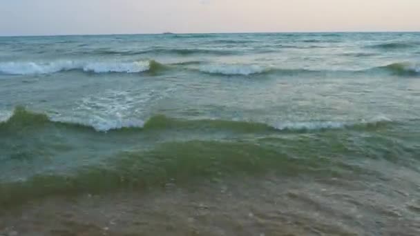 穏やかな波が砂浜を横切っています 海や海で日没する 水の動きについて 波は泡で激しくなっている 観光パラダイス 砂は海の水柱を通して見える ブラック — ストック動画
