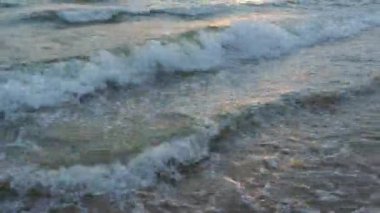 Sakin dalgalar kumlu sahilde yuvarlanıyor. Denizde ya da okyanusta gün batımı. Su hareketi. Dalgalar köpükten köpürüyor. Turist cenneti. Akşamları deniz manzarası çok güzeldir. Karadeniz. İş olarak turizm