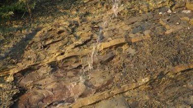 Flysch, çoğunlukla klasikleşmiş deniz tortulu bir kaya serisidir. Litolojik katmanların değişmesi. Bir kayadan akan su ya da kanalizasyon akıntısı. Kafkas Dağları.