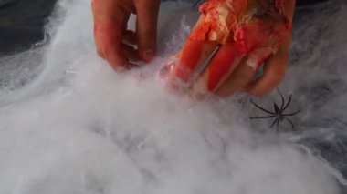 Derisi soyulmuş kanlı canavarlar ağlarına bir kaç insan gözü yerleştirir, düzenler ve saklar. Cadılar Bayramı ve korku. Ellerinden ve parmaklarından deri parçaları sarkıyor. Yaşlı cadı.