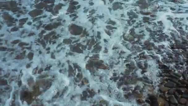 波は海で小石の上に飛び散った 海のビーチ 波がバックグラウンドをクラッシュ 波は小石の上に飛び散った 小石の気泡について 職業夏休みのコンセプト カフカス山脈 — ストック動画