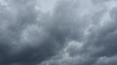 Gökyüzü ve gri bulutlar. Kabarık, siyah bulutlar. Kümülüs bulutları zaman aşımına uğrar. Sonbahar ya da kış gökyüzü zaman aşımı. Doğa hava tahmini. Yağmurlu bulutların arka planı. Bulut dramatik hızlı video fırtınası.