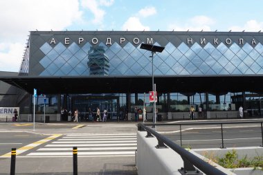 Belgrad, Sırbistan 09.17.2023 Nikola Tesla Uluslararası Surcin Havaalanı. Yeni havaalanı binaları. Uçakla uçan yolcu trafiğini arttır. Arabalar, insanlar, otobüs durağı, park yeri. Cam havaalanı duvarları.