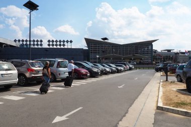 Belgrad, Sırbistan 09.17.2023 Nikola Tesla Uluslararası Surcin Havaalanı. Yeni havaalanı binaları. Uçakla uçan yolcu trafiğini arttır. Arabalar, insanlar, otobüs durağı, park yeri. Cam havaalanı duvarları.